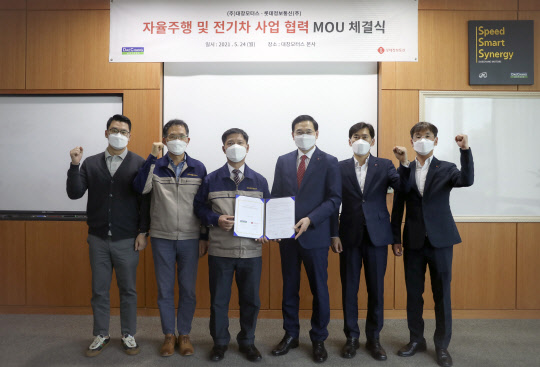 오영식(왼쪽에서 네번째) 롯데정보통신 스마트시티부문장과 오충기(세번째) 대창모터스 대표가 제휴를 맺고 기념촬영을 하고 있다. 롯데정보통신 제공